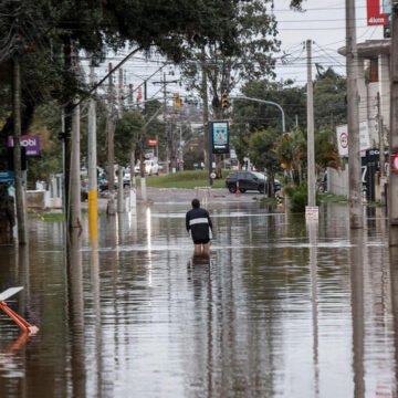 Persona caminando por una calle completamente inundada tras un evento climático extremo en Bahía Blanca, Argentina.